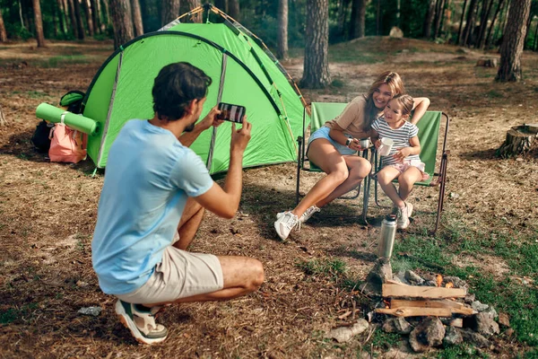 Szczęśliwa Rodzina Siedząca Przy Ognisku Pobliżu Namiotu Sosnowym Lesie Weekend — Zdjęcie stockowe