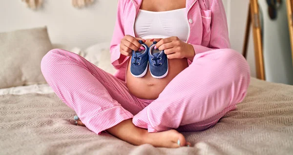 Una Joven Embarazada Sostiene Suavemente Pequeños Zapatos Bebé Sus Manos —  Fotos de Stock