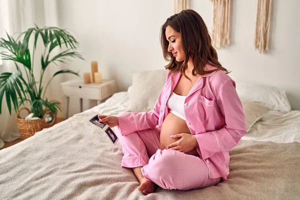 Una Giovane Donna Incinta Tiene Delicatamente Mano Immagine Ecografica Del — Foto Stock