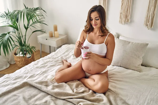 Mujer Embarazada Joven Ropa Interior Blanca Sienta Cama Dormitorio Come —  Fotos de Stock