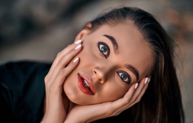 Gün batımında kumsalda poz veren uzun saçlı güzel bir esmerin yakın plan portresi. Doğanın keyfi..