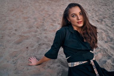 Gün batımında kumsalda dinlenen uzun saçlı güzel bir esmerin portresi. Doğanın keyfi..