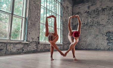 Fitness, esneme antrenmanı, yoga yapan iki çekici kadın grubu. Sağlık konsepti. Ortak yogası. Denge, konsantrasyon, denge kavramı.