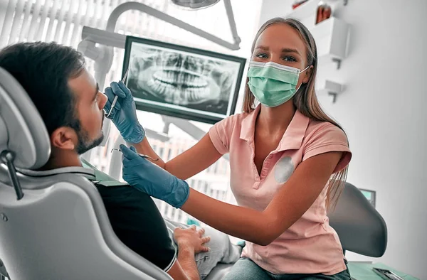 Odontóloga Con Máscara Examinando Una Paciente Con Herramientas Clínica Dental —  Fotos de Stock