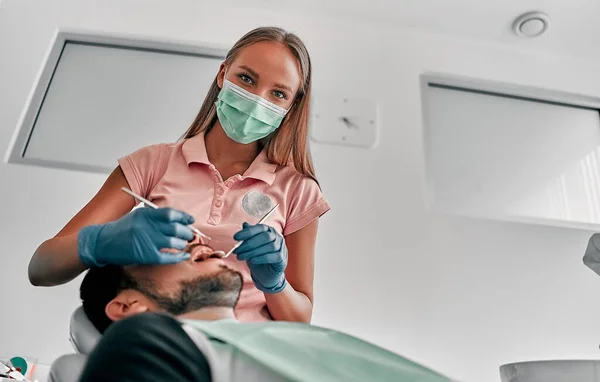 Odontóloga Con Máscara Examinando Una Paciente Con Herramientas Clínica Dental —  Fotos de Stock