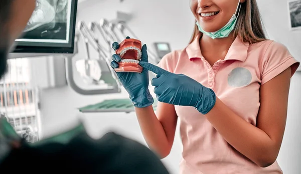 Mujer Dentista Sosteniendo Dientes Modelo Dentadura Postiza Mostrando Explicando Paciente —  Fotos de Stock