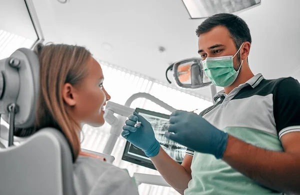 Joven Dentista Que Trabaja Examina Repara Los Dientes Una Clínica —  Fotos de Stock