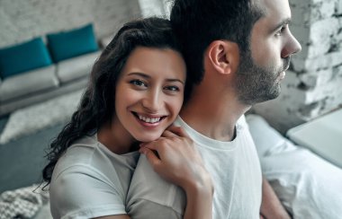 Yatakta sarılan genç ve güzel bir çift. Evli bir çiftin sabah konsepti.