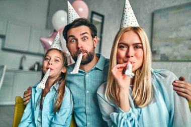 Doğum günü partisi. Aile kızının doğum gününü kutluyor, partide eğleniyor, doğum günü şapkası takıyor. Aile güzel anları.