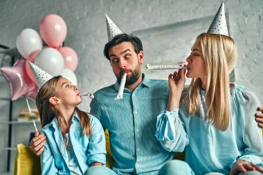 Doğum günü partisi. Aile kızının doğum gününü kutluyor, partide eğleniyor, doğum günü şapkası takıyor. Aile güzel anları.