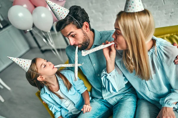 Doğum günü partisi. Aile kızının doğum gününü kutluyor, partide eğleniyor, doğum günü şapkası takıyor. Aile güzel anları.