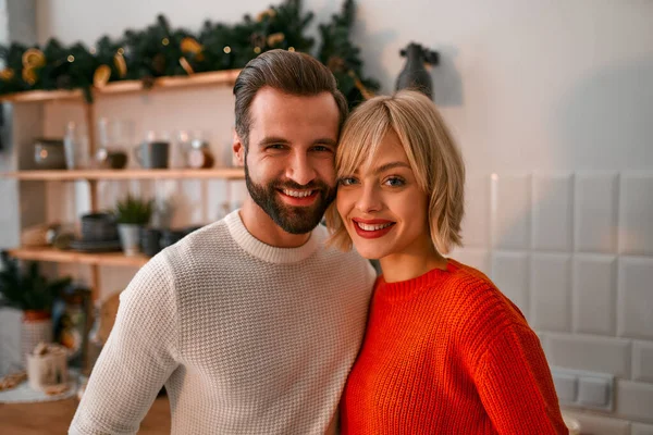メリークリスマスとハッピーニューイヤー キッチンにはかわいいカップルが立っています クリスマスツリーの枝が並んでいます — ストック写真