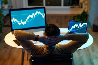 Bilgisayar ekranına bakan kripto tüccar yatırımcısı analizcisi bilgisayar ekranındaki finansal verileri analiz ediyor ve bilgisayar ekranında online borsa ticareti, yatırım ticareti gibi küresel riskleri düşünüyor..