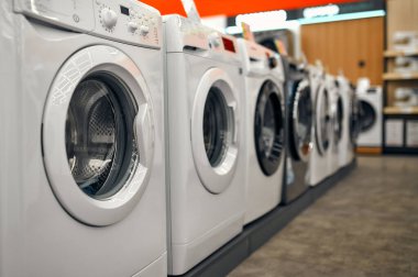 Bir alet, elektronik ve ev aletleri mağazasında vitrinlerin üzerinde çeşitli şık çamaşır makineleri..