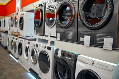Bir alet, elektronik ve ev aletleri mağazasında vitrinlerin üzerinde çeşitli şık çamaşır makineleri..