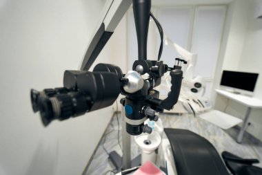 Detaylı diş cerrahisi için gerekli tüm ekipman ve diş mikroskobuyla modern bir diş hekiminin parlak iç mekanı..