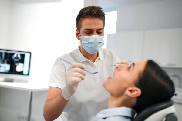 Joven Dentista Con Máscara Médica Examinando Una Paciente Consultorio Dental —  Fotos de Stock