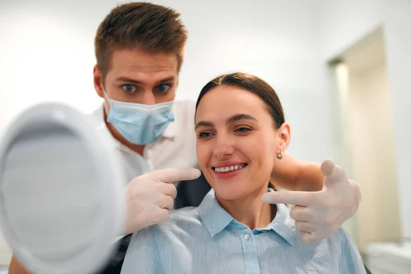 Paciente Femenina Sonriente Con Aparatos Ortopédicos Mirándose Espejo Examen Dentista —  Fotos de Stock
