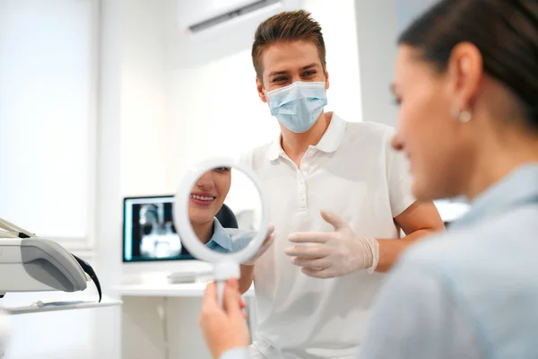 Paciente Femenina Sonriente Con Aparatos Ortopédicos Mirándose Espejo Examen Dentista —  Fotos de Stock