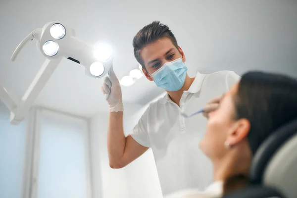 Joven Dentista Con Máscara Médica Examinando Una Paciente Consultorio Dental —  Fotos de Stock