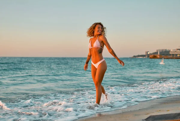 Çekici Beyaz Kadın Bikinili Mayo Giymiş Güneş Doğarken Sahilde Geziniyor — Stok fotoğraf