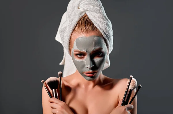 Poważna Kobieta Glinianą Maską Twarzy Trzyma Rękach Profesjonalne Szczotki Zdjęcie — Zdjęcie stockowe