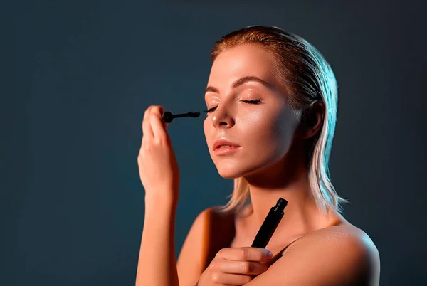 Ein Schönes Mädchen Mit Blonden Haaren Bemalt Ihre Wimpern Mit — Stockfoto