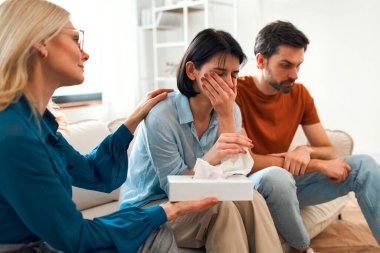 Genç evli bir çift bir psikoterapist ile görüşmeye geldi. Depresyon sırasında danışmanlık ve yardım ve aile sorunlarını çözmek. Kadın psikoloğa ağlıyor..