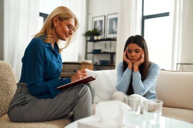 Bir psikoloğun resepsiyonundaki mutsuz kız. Müşteri sorunlardan bahsediyor. Aile sorunları, ergenlik sorunları. Bir terapistle konuşmak, tavsiye, yardım kavramı.
