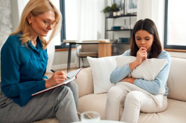 Bir psikoloğun resepsiyonundaki mutsuz kız. Müşteri sorunlardan bahsediyor. Aile sorunları, ergenlik sorunları. Bir terapistle konuşmak, tavsiye, yardım kavramı.