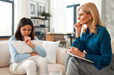 Bir psikoloğun resepsiyonundaki mutsuz kız. Müşteri sorunlardan bahsediyor. Aile sorunları, ergenlik sorunları. Bir terapistle konuşmak, tavsiye, yardım kavramı.