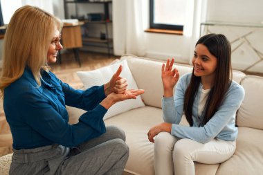 Psikolog randevusunda tatlı bir kız. Hastası olan psikolog kadın el kol hareketleri yapıyor ve onaylıyor. Aile sorunları, ergenlik sorunları. Bir terapistle konuşmak, tavsiye, yardım kavramı