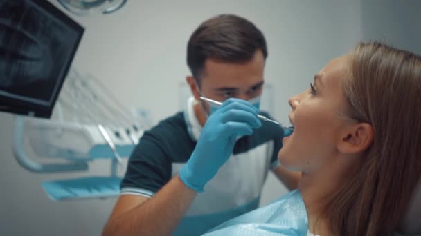 Male Dentist Protective Medical Mask Using Tools Examines Patient Oral — Stockvideo