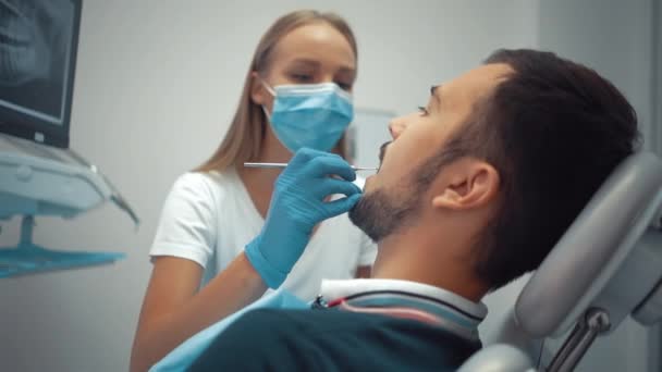 Female Dentist Protective Medical Mask Using Tools Examines Patient Oral — Vídeos de Stock