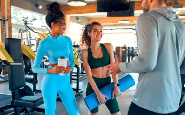 Spordan ve sohbetten sonra spor salonunda duran bir grup narin atletik genç. Aktif sağlıklı yaşam tarzı, spor.