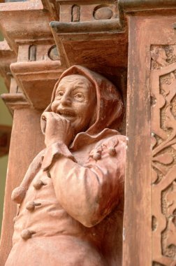 Avusturya 'daki Schallaburg Kalesi' nin Rönesans binasının iç bahçesindeki balkonda oturan bir aptal figürü.