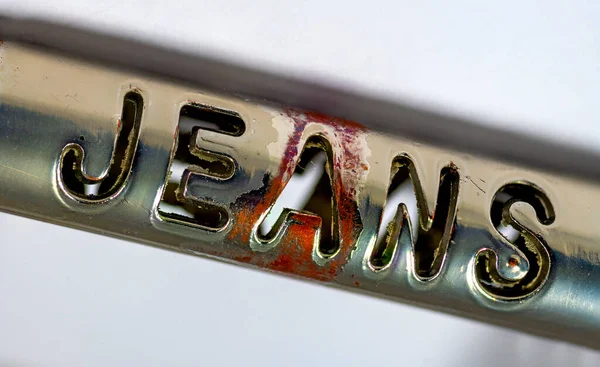 金属製のベルトバックルに Jeans というパンチアウトされた単語の近くで — ストック写真