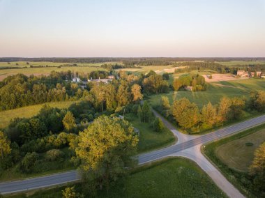 Sonbahar renklerinde kırsal yollar ve günbatımı ışığı. Zeminin üstündeki dron görüntüsü
