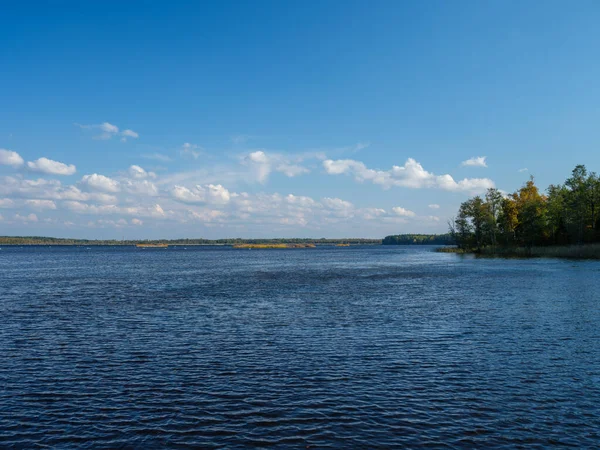 Kır ormanı gölü yazın koyu mavi sularda yansımalar ve kıyılarda yeşil ağaçlarla
