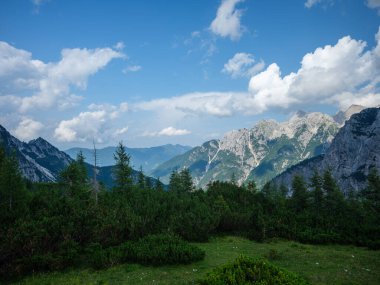 Slovenya 'daki Triglav parkında, mavi bulutlu gökyüzünün altında ve zirvelerinde. Güneşli yaz günü