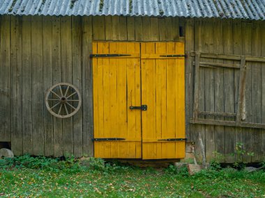 Yazın kırsal alanda ahşap tahtalar ve betondan yapılmış eski bir ahır.