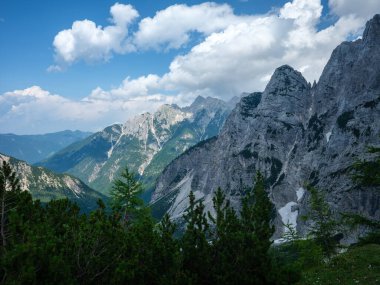 Slovenya 'daki Triglav parkında, mavi bulutlu gökyüzünün altında ve zirvelerinde. Güneşli yaz günü