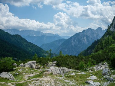 Slovenya 'daki Triglav parkında, mavi bulutlu gökyüzünün altında ve zirvelerinde. Güneşli yaz günü