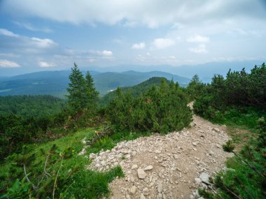 Güneşli yaz gününde alçak bulutlarla yürüyüş için kayalık dağ turizmi yolları