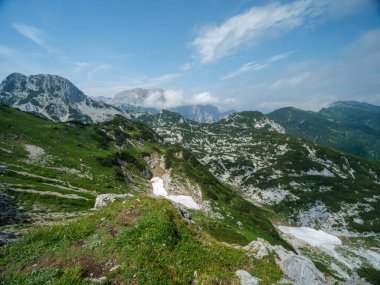 Güneşli yaz gününde alçak bulutlarla yürüyüş için kayalık dağ turizmi yolları
