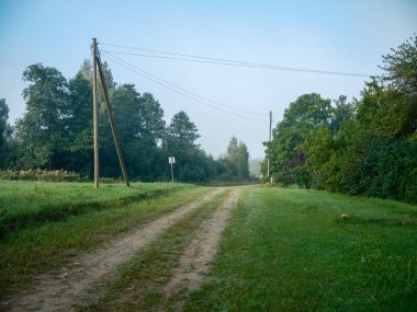 Kırsal kesimde su olan ıslak çakıl yolu. Sonbahar günü manzarası