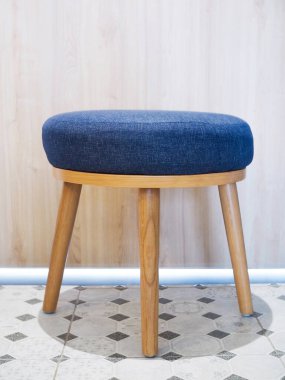 küçük ahşap taburesi olan mobilyalar mavi koltuk minderleri oda zeminine yerleştirilmiş..