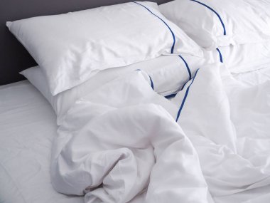 Yataktaki yastıklar, kırışık battaniyeler.