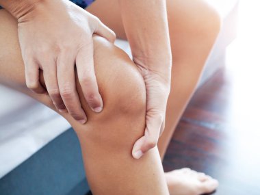 Dizi ve bacağı ağrıyan Asyalı kadınların yakın çekimleri acıyı dindirmek için ellerle masaj yapıyorlar.