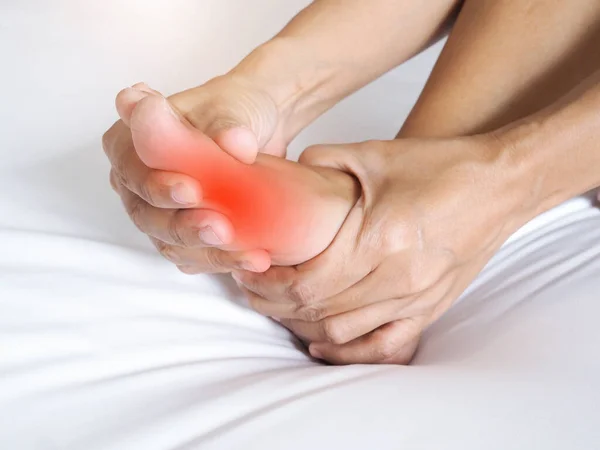 Asian people suffering from severe foot pain. hands reflexology massage pressure points on feet to relieve pain.